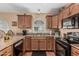 Well-organized kitchen featuring tiled countertops and modern black appliances at 18297 W Spencer Dr, Surprise, AZ 85374