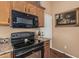 Close up of a modern black oven and microwave in a kitchen with wooden cabinets at 18297 W Spencer Dr, Surprise, AZ 85374