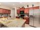 Bright kitchen featuring granite counters, stainless steel refrigerator and wood cabinets at 18669 W Vista Norte St, Goodyear, AZ 85338