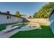 This backyard features a swimming pool with a diving board and is surrounded by artificial turf for a low-maintenance outdoor space at 217 E Bruce Ave, Gilbert, AZ 85234