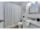 Bright bathroom featuring granite counters, white cabinets, and a shower with patterned curtain at 217 E Bruce Ave, Gilbert, AZ 85234