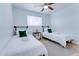 Bright bedroom with hardwood floor and ceiling fan featuring two beds with white linens and green pillows at 217 E Bruce Ave, Gilbert, AZ 85234