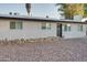 Exterior view with low-maintenance landscaping, dark trim, and a gray front door at 217 E Bruce Ave, Gilbert, AZ 85234