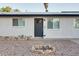 Exterior view of the front of the house with xeriscaped yard and gray front door at 217 E Bruce Ave, Gilbert, AZ 85234