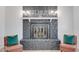 Close-up of the living room's stone fireplace and mantel with decor and seating at 217 E Bruce Ave, Gilbert, AZ 85234