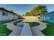 Backyard pool with diving board surrounded by green grass and mature trees at 217 E Bruce Ave, Gilbert, AZ 85234