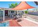 Inviting backyard with shade cover, patio furniture, hot tub, and well-maintained landscaping at 2221 W Mitchell Dr, Phoenix, AZ 85015