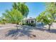 Charming single story home features a rock yard, mature trees, and a covered front porch at 2221 W Mitchell Dr, Phoenix, AZ 85015
