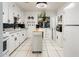 Bright kitchen with white cabinets, modern appliances, and a versatile rolling island at 2221 W Mitchell Dr, Phoenix, AZ 85015
