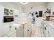 Spacious kitchen with lots of storage, island, white appliances and a laundry area at 2221 W Mitchell Dr, Phoenix, AZ 85015