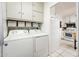 Functional laundry area featuring appliances, storage cabinets, and a glimpse into the adjacent kitchen at 2221 W Mitchell Dr, Phoenix, AZ 85015