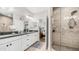 Bright bathroom featuring double sinks, vanity with white cabinets and a glass enclosed shower at 2511 W Queen Creek Rd # 166, Chandler, AZ 85248