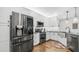 Well-lit kitchen features stainless steel appliances, white cabinetry, and hardwood flooring at 2511 W Queen Creek Rd # 166, Chandler, AZ 85248