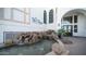 The Cays at Downtown Ocotillo building entrance with a rock waterfall feature and greenery at 2511 W Queen Creek Rd # 166, Chandler, AZ 85248