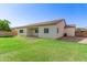 Backyard featuring lush grass, mature landscaping, and a covered patio area at 259 E Montego Dr, Casa Grande, AZ 85122