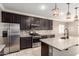 Spacious open kitchen featuring granite countertops, stainless steel appliances, a central island, and dark cabinetry at 259 E Montego Dr, Casa Grande, AZ 85122