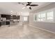 Open floor plan showcasing kitchen and living room with large windows, ceiling fan, and tile flooring at 259 E Montego Dr, Casa Grande, AZ 85122