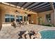Covered patio with a fire pit, comfortable seating, ceiling fans, and access to the pool at 32020 N 20Th Dr, Phoenix, AZ 85085