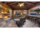 Covered outdoor living area with a fireplace, outdoor bar, and seating overlooking the pool at 32020 N 20Th Dr, Phoenix, AZ 85085