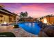 Outdoor pool featuring a waterfall, tiled patio, and covered seating area, great for entertaining during dusk at 32020 N 20Th Dr, Phoenix, AZ 85085