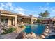 Picturesque backyard with a resort-style pool, stone accents, and a covered area with lounge chairs at 32020 N 20Th Dr, Phoenix, AZ 85085