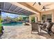 Beautiful covered patio with a view of the pool and waterfall feature, ideal for relaxation and outdoor living at 32020 N 20Th Dr, Phoenix, AZ 85085