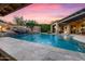 Beautiful backyard pool area with rock waterfall and lush landscaping under a colorful evening sky at 32020 N 20Th Dr, Phoenix, AZ 85085