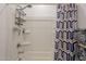 Clean bathroom featuring a bathtub with shower head, white shower walls, and shower curtain at 32729 N Mach Ln, San Tan Valley, AZ 85143