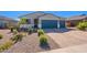Beautiful single-story home with blue garage doors, a well-maintained yard, and professional landscaping at 32729 N Mach Ln, San Tan Valley, AZ 85143