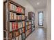 Hallway featuring built-in bookshelves with tile floor leading to a frosted-glass front door at 32729 N Mach Ln, San Tan Valley, AZ 85143
