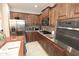 Well-lit kitchen with stainless steel appliances, granite countertops, and dark wood cabinets at 3581 S Arizona Pl, Chandler, AZ 85286