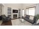 Bright living room with a fireplace, neutral tones, wood floors, and built-in shelving at 3581 S Arizona Pl, Chandler, AZ 85286