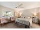 Cozy bedroom with a ceiling fan, a large window, two chairs, and a comfortable bed, creating a relaxing retreat at 4010 E Coolidge St, Phoenix, AZ 85018