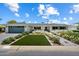 Charming home with a well-manicured front yard, complete with lush green grass and beautiful white flowers at 4010 E Coolidge St, Phoenix, AZ 85018