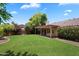 Well-maintained backyard with lush lawn, mature trees, a covered patio, and privacy for outdoor enjoyment at 4223 E Danbury Rd, Phoenix, AZ 85032
