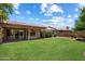 Expansive backyard with green lawn, covered patio, mature landscaping, and serene views of neighboring homes at 4223 E Danbury Rd, Phoenix, AZ 85032