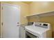 Efficient laundry room with shelving and modern, white LG washer and dryer at 4223 E Danbury Rd, Phoenix, AZ 85032