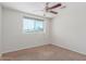 Bright, carpeted bedroom with a large window and ceiling fan at 4238 W Krall St, Phoenix, AZ 85019