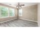 Bright bedroom featuring a ceiling fan and three large windows with views at 4277 N 180Th Ln, Goodyear, AZ 85395