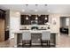 A modern kitchen with dark cabinets, granite countertops, and stainless steel appliances at 4277 N 180Th Ln, Goodyear, AZ 85395