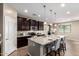 A modern kitchen with dark cabinets, granite countertops, and stainless steel appliances at 4277 N 180Th Ln, Goodyear, AZ 85395