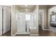 Main bathroom showcasing a walk-in shower, glass enclosure and built-in bench with access to walk-in closet and bedroom at 4277 N 180Th Ln, Goodyear, AZ 85395