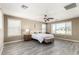 Spacious bedroom with large windows offering plenty of natural light and complete with ceiling fan and wood-look flooring at 4277 N 180Th Ln, Goodyear, AZ 85395