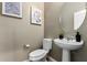 Cozy powder room featuring a pedestal sink, an oval mirror, and stylish wall decor to create a fresh, modern look at 4277 N 180Th Ln, Goodyear, AZ 85395