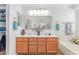 Bathroom features a dual sink vanity with framed mirrors and tub at 44853 W Jack Rabbit Trl, Maricopa, AZ 85139