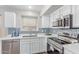 This kitchen features white cabinets, stainless steel appliances, and stylish backsplash at 44853 W Jack Rabbit Trl, Maricopa, AZ 85139