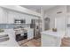 Bright kitchen features stainless steel appliances, white cabinetry and countertops, with a colorful backsplash at 44853 W Jack Rabbit Trl, Maricopa, AZ 85139