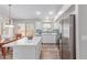 Open kitchen with quartz countertops, white cabinets, stainless appliances, and a view of the dining area at 44853 W Jack Rabbit Trl, Maricopa, AZ 85139