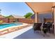 Outdoor patio area with pool, seating, and a soothing rock waterfall feature at 44853 W Jack Rabbit Trl, Maricopa, AZ 85139