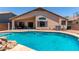 Sparkling backyard pool with rock features and a covered patio, perfect for relaxation and entertaining at 44853 W Jack Rabbit Trl, Maricopa, AZ 85139